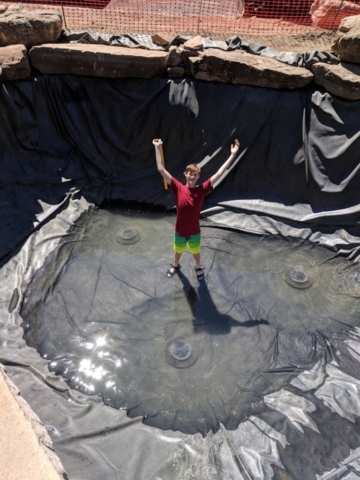 My nephew helped me pull the wrinkles up as we slowly filled the pond.